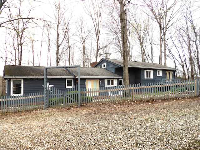 ranch-style house with a chimney and a fenced front yard