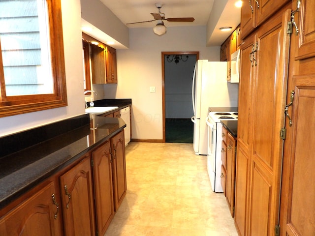 kitchen featuring a sink, light floors, brown cabinets, and white appliances