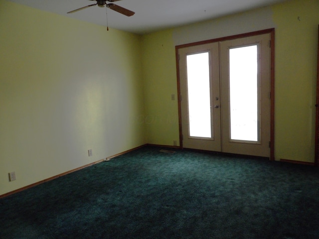 carpeted empty room with a ceiling fan, baseboards, and french doors
