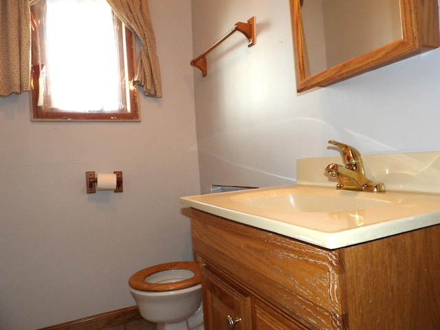 half bath featuring vanity and toilet