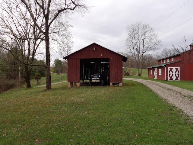 view of pole building with a barn, a yard, and gravel driveway