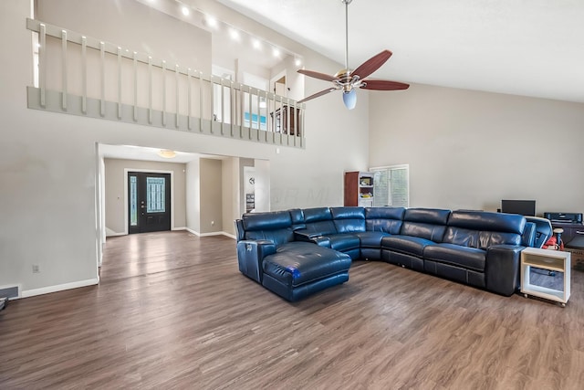 living area featuring baseboards, a ceiling fan, wood finished floors, and high vaulted ceiling