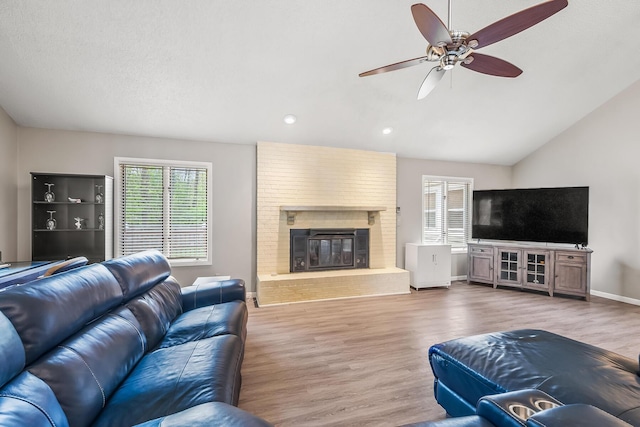 living room with plenty of natural light, a ceiling fan, lofted ceiling, and wood finished floors