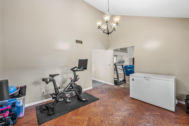 exercise room with a notable chandelier, visible vents, baseboards, and high vaulted ceiling