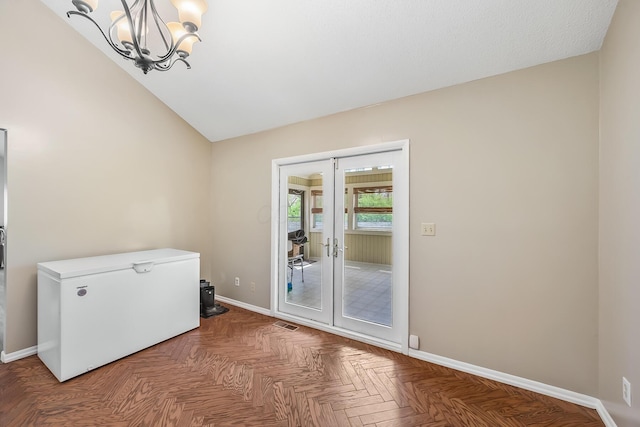unfurnished room with baseboards, a chandelier, and french doors