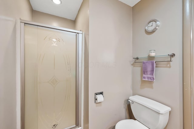 bathroom with toilet and a shower stall