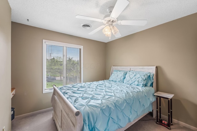 carpeted bedroom featuring visible vents, a textured ceiling, baseboards, and ceiling fan