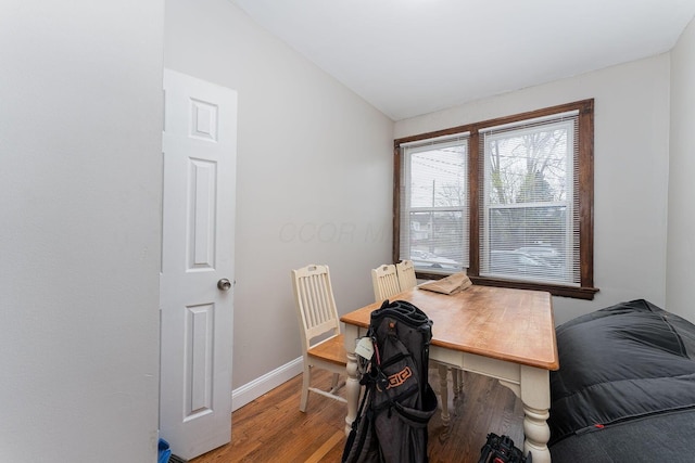 office area with lofted ceiling, baseboards, and wood finished floors