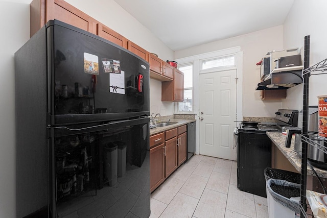 kitchen with a sink, black appliances, light tile patterned flooring, and light stone countertops
