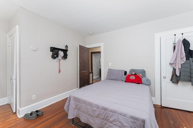 bedroom with baseboards and wood finished floors