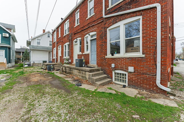 view of front of property featuring brick siding and cooling unit