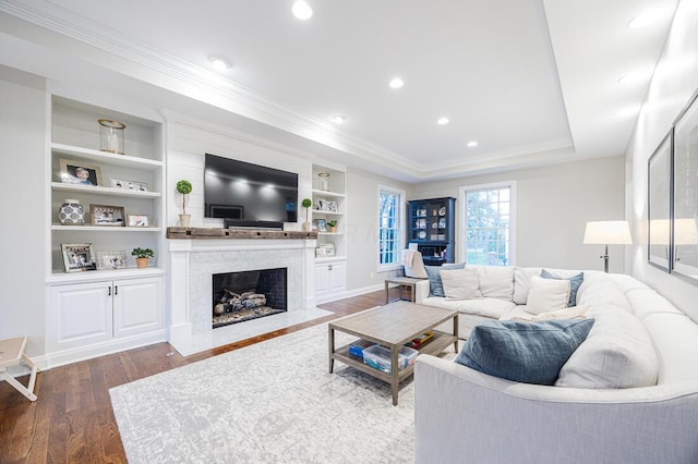 6920 Clivdon Mews, New Albany, OH 43054 - living area with built in features, a fireplace, ornamental molding, wood finished floors, and a raised ceiling