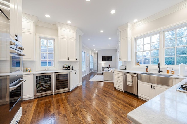 6920 Clivdon Mews, New Albany, OH 43054 - kitchen with beverage cooler, light countertops, crown molding, and appliances with stainless steel finishes