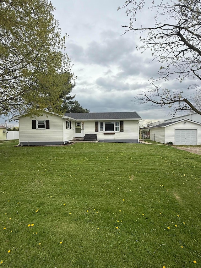 view of front of property with roof with shingles, an outbuilding, a front yard, and a garage