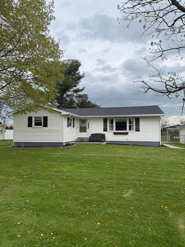 back of property with entry steps and a lawn
