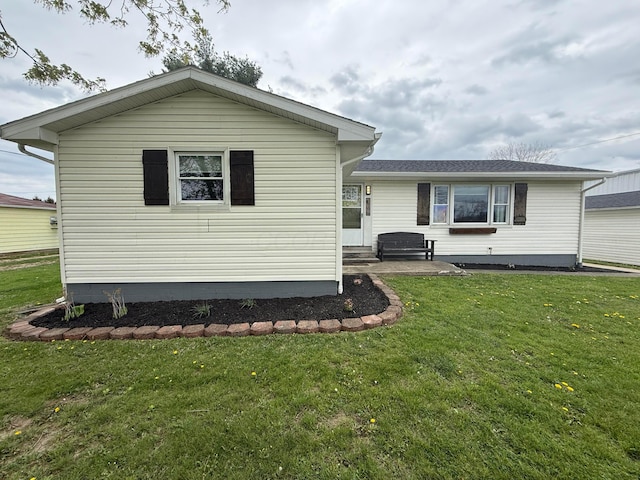rear view of house with a yard and entry steps