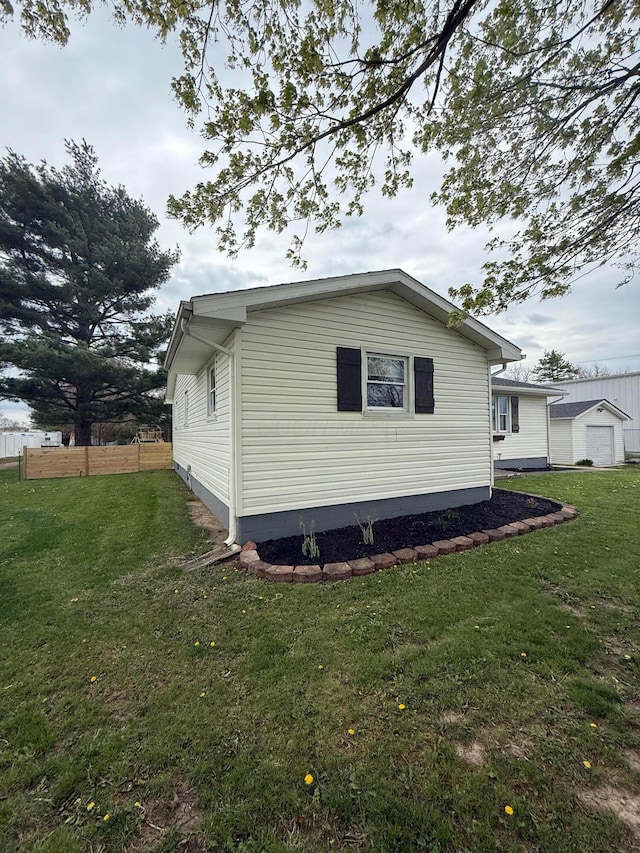 view of home's exterior with a lawn and fence