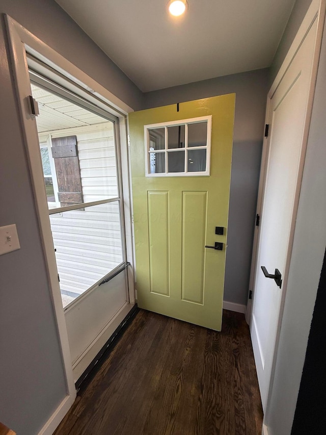 doorway with baseboards and dark wood-style floors