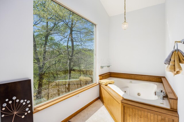 bathroom with a whirlpool tub, baseboards, and lofted ceiling