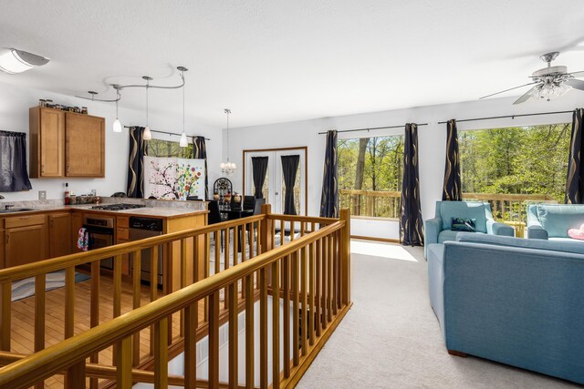 interior space with light colored carpet and ceiling fan with notable chandelier