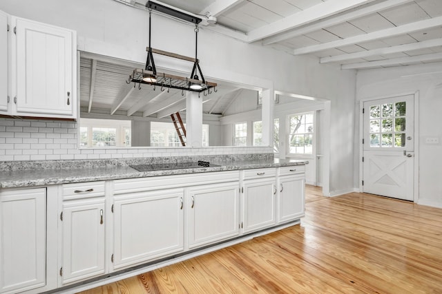 13384 Orchard Is NE, Millersport, OH 43046 - kitchen featuring black electric stovetop, white cabinets, beamed ceiling, light wood-style flooring, and backsplash