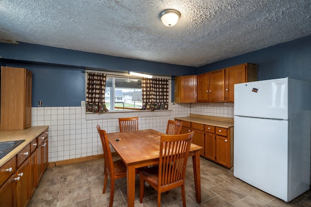 751 Bobo Rd, Beaver, OH 45613 - kitchen with light countertops, brown cabinetry, and freestanding refrigerator