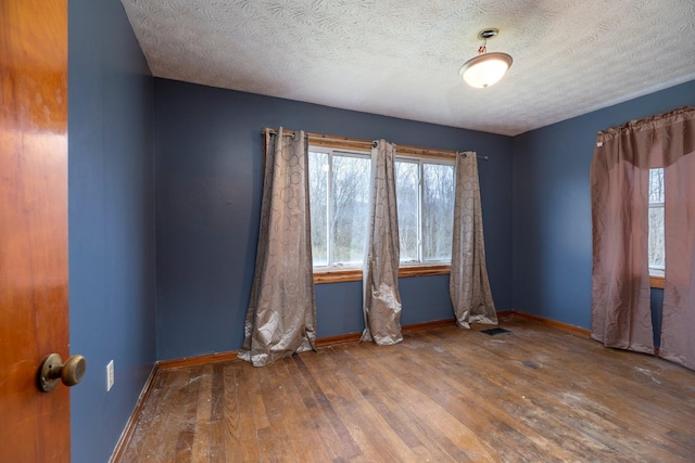 751 Bobo Rd, Beaver, OH 45613 - empty room with a textured ceiling, baseboards, visible vents, and hardwood / wood-style flooring