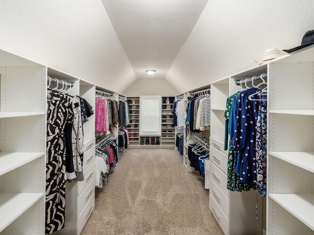 spacious closet with light colored carpet and lofted ceiling