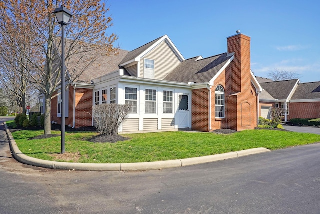 5955 Glen Village Dr, Dublin, OH 43016 - view of front of house with a chimney, a shingled roof, a front yard, and brick siding