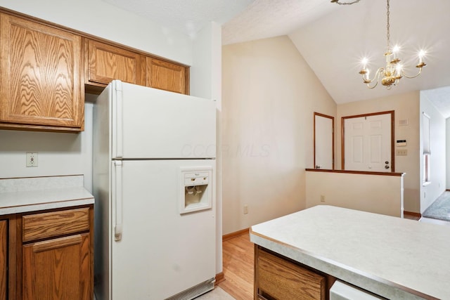 5955 Glen Village Dr, Dublin, OH 43016 - kitchen with an inviting chandelier, white fridge with ice dispenser, light countertops, brown cabinetry, and lofted ceiling