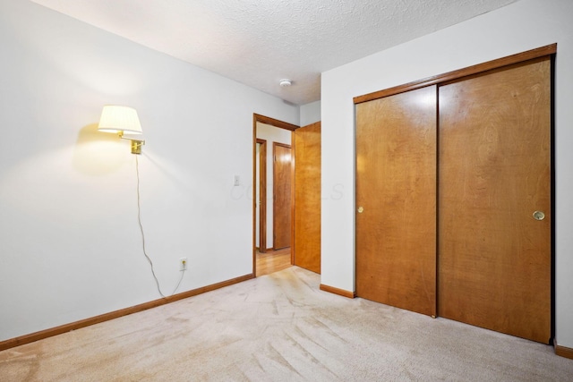 5955 Glen Village Dr, Dublin, OH 43016 - unfurnished bedroom with light carpet, a closet, baseboards, and a textured ceiling