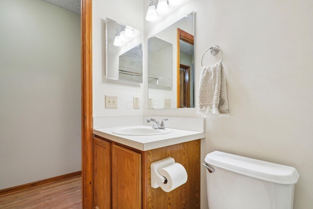 5955 Glen Village Dr, Dublin, OH 43016 - half bath featuring toilet, wood finished floors, vanity, and baseboards