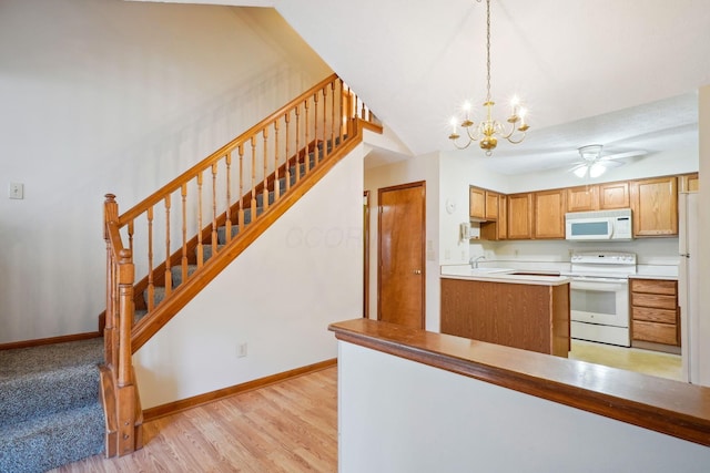 5955 Glen Village Dr, Dublin, OH 43016 - kitchen featuring baseboards, white appliances, light wood-style floors, ceiling fan with notable chandelier, and pendant lighting