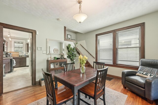 1287 City Park Ave, Columbus, OH 43206 - dining space with baseboards, light wood-style floors, and stairs
