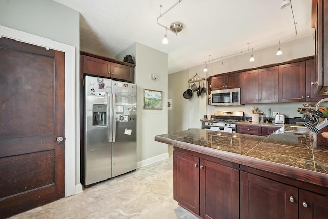1287 City Park Ave, Columbus, OH 43206 - kitchen with stainless steel appliances, tile countertops, a sink, a peninsula, and baseboards