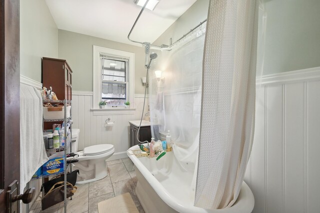 1287 City Park Ave, Columbus, OH 43206 - bathroom with a wainscoted wall, toilet, a shower with shower curtain, a tub to relax in, and a decorative wall