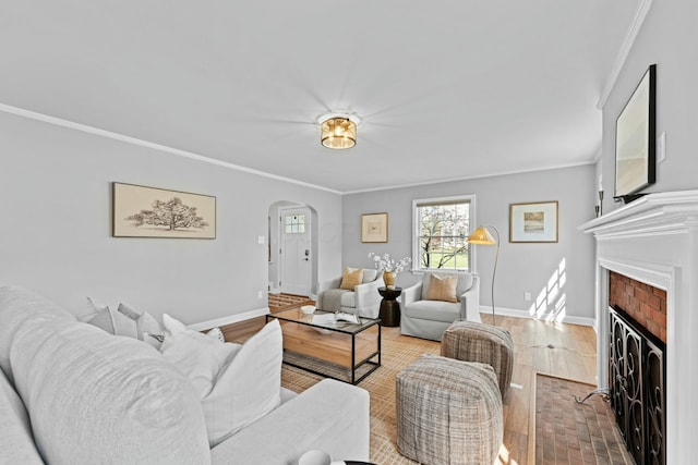 living room with arched walkways, baseboards, and ornamental molding