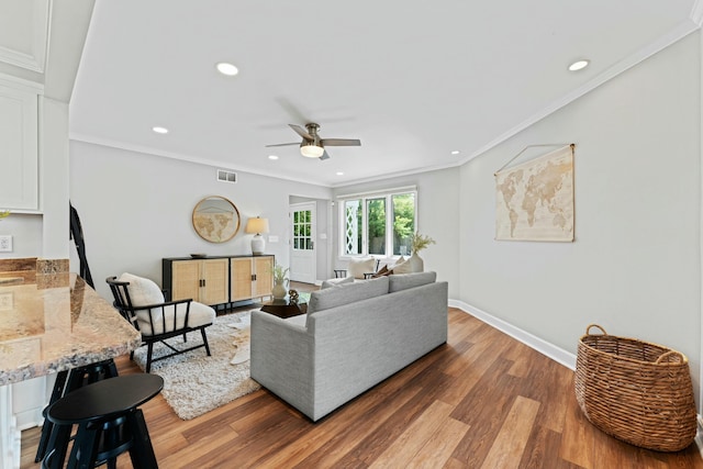 living area with a ceiling fan, wood finished floors, baseboards, visible vents, and recessed lighting