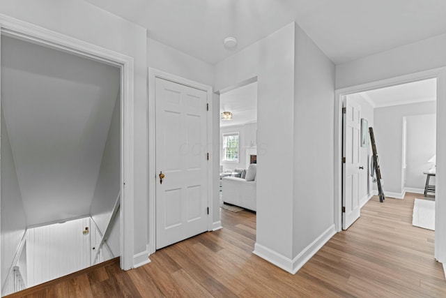 hall featuring light wood finished floors and baseboards