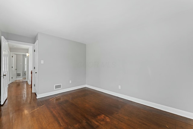 interior space featuring visible vents, baseboards, and dark wood-style flooring