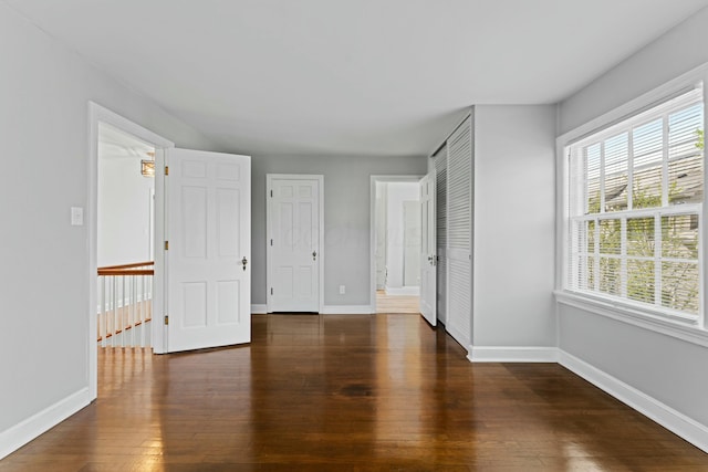 unfurnished bedroom featuring hardwood / wood-style flooring and baseboards