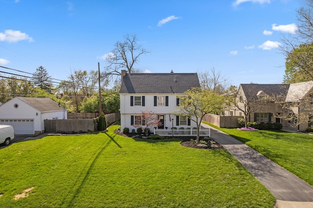 view of front of house with a chimney, fence, a front lawn, covered porch, and a garage