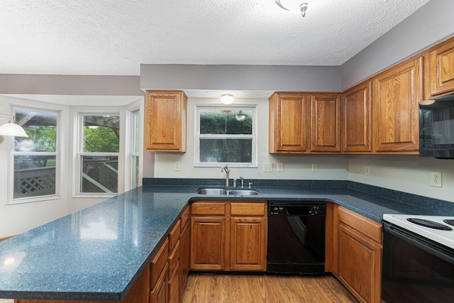 5516 Latrobe St, Westerville, OH 43081 - kitchen featuring black appliances, a sink, light wood-style floors, dark countertops, and a textured ceiling