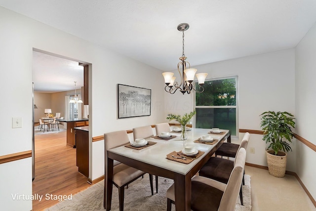 5516 Latrobe St, Westerville, OH 43081 - dining area featuring a chandelier, healthy amount of natural light, light wood-style floors, and baseboards