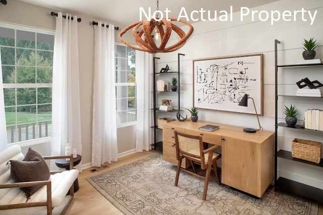 office featuring visible vents, a wealth of natural light, light wood finished floors, and a chandelier