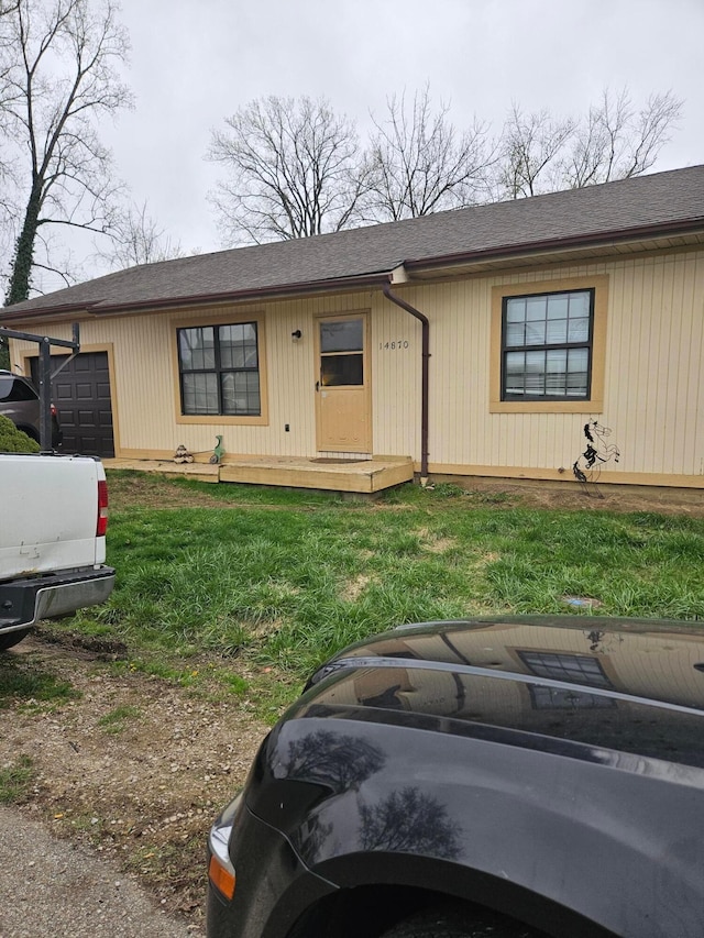 view of front facade featuring a front yard and an attached garage