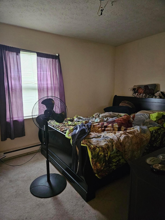 carpeted bedroom featuring a baseboard radiator and a textured ceiling