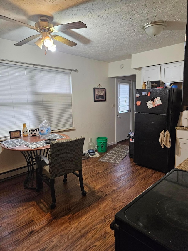 dining room with a textured ceiling, ceiling fan, baseboards, and dark wood finished floors