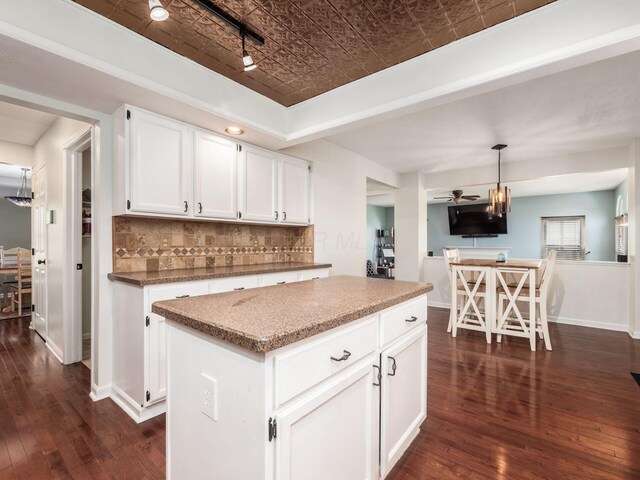 kitchen featuring white cabinetry, decorative backsplash, dark wood finished floors, and an ornate ceiling