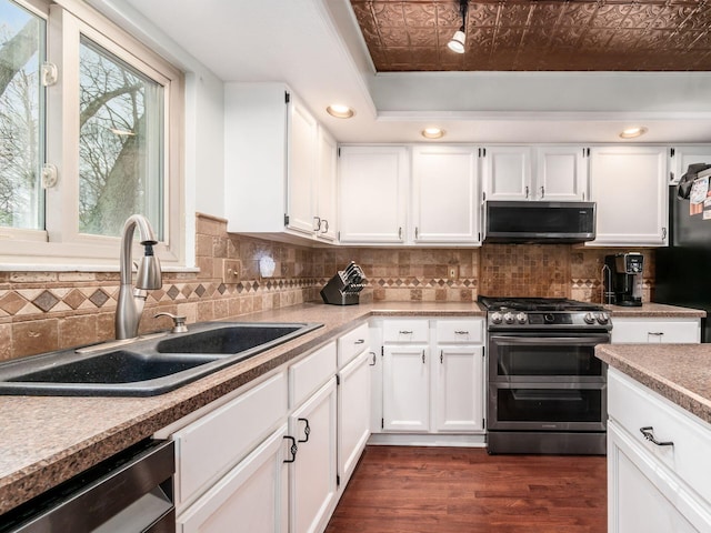 kitchen with a sink, an ornate ceiling, appliances with stainless steel finishes, and white cabinetry